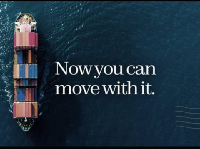 An aerial view of a colorful container ship sailing on dark blue water with the text 'Now you can move with it.' overlaid in white serif font.
