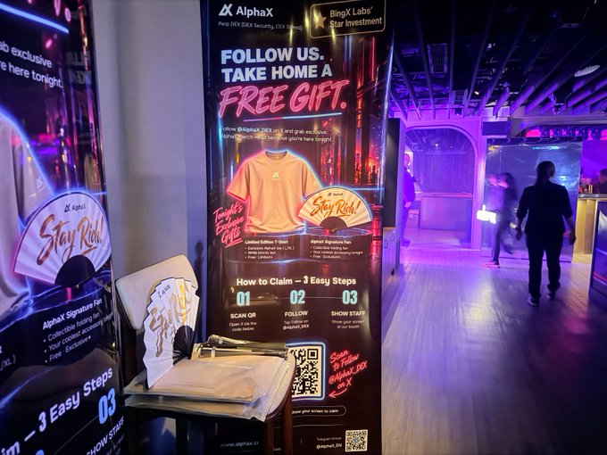 An event space with neon purple and blue lighting features a promotional banner for AlphaX offering a 'FREE GIFT' with a 'Follow Us, Take Home A Free Gift' campaign, including a fan and orange 'Stay Rich!' t-shirt, with 3 easy steps: scan QR, follow, and show staff.