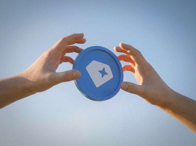 Two hands reaching toward each other against a blue sky, with a blue circular token featuring a white star and tag logo floating between them.