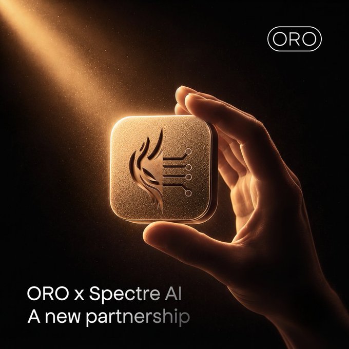 A hand holds a glowing gold device featuring flame and circuit engravings, with "ORO" branding in the top right and text reading "ORO x Spectre AI - A new partnership" at the bottom, visually promoting the new collaboration between ORO and Spectre AI mentioned in the post.