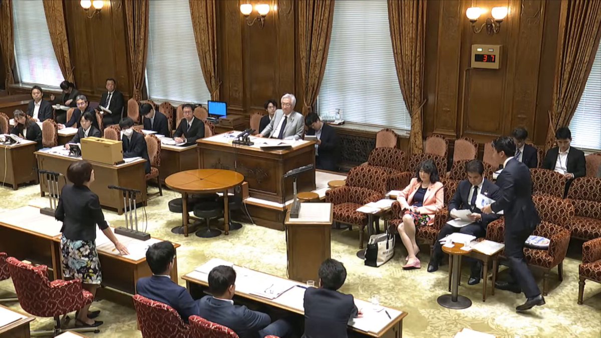 The image shows a group of people sitting around a table, with some standing near them. The room appears to be a courtroom or a similar setting where people are gathered for an event. There are several chairs placed throughout the scene, as well as a few dining tables in different parts of the room. A judge is present at one end of the room, and there's a laptop on one of the tables.

The post accompanying this image provides information about the event taking place, including details such as the number of people attending, the name of the judge, and the location where it took place. The image also includes some text that reads "なんだけの人みましたは問題ですか？ アンカーで自行官になりましたが！何か問題ですか".