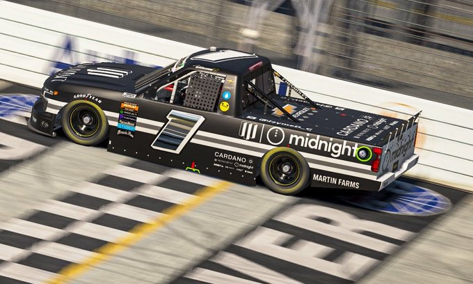 A black #0 racing truck with 'midnight' and 'CARDANO' sponsorship logos crosses the finish line.