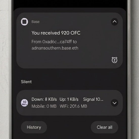 The image shows a cell phone screen with a message from someone named "Base" who has received 990 OFC tokens as a gift. The text of the message reads, "I received 990 OFC tokens on the Base network and I'm holding it!! This generous vesting is a wonderful gesture that truly makes me happy. I appreciate your support and the opportunity to be part of this amazing community."