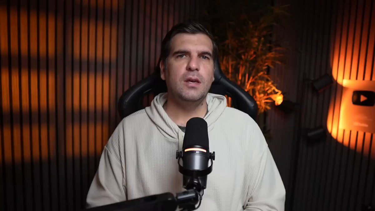 The image shows a man wearing a white sweater sitting behind a microphone, likely recording or broadcasting something related to cryptocurrency or financial news. The background features a dark wall with orange lights, which could be used for video conferencing or streaming purposes. The caption provided in the image suggests that there is an update on XRP Ledger and how it impacts lending protocols, possibly related to the native lending protocol.

The man's position behind the microphone indicates he is speaking into a recording device, such as a podcast or live stream, rather than directly interacting with the camera. The focus of the image is on the content being discussed in the caption, which provides information about the new native lending protocol and its implications for the XRP Ledger.