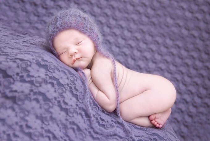 A peacefully sleeping newborn curled up on a lavender knit blanket, matching the post’s good-night message about rest, letting go of noise, and starting fresh tomorrow.