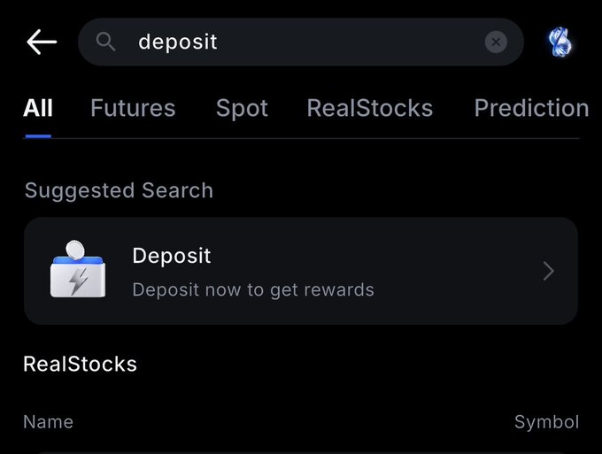 A dark-themed trading app shows a search for “deposit,” with a suggested “Deposit—Deposit now to get rewards” action and tabs for All, Futures, Spot, RealStocks, and Prediction.