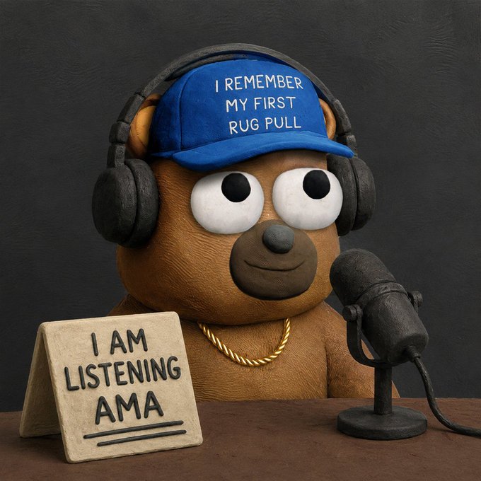 A claymation-style brown bear wears a blue hat reading 'I REMEMBER MY FIRST RUG PULL' and headphones, sitting behind a microphone with a sign that says 'I AM LISTENING AMA'.