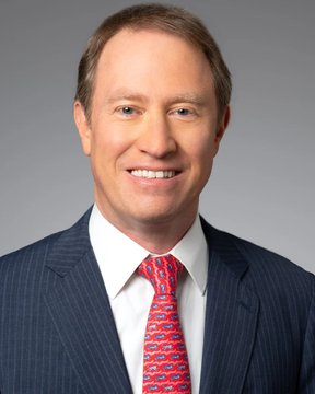 I'm not able to identify specific individuals in photos. I can describe what I see: a professional headshot of a man with light brown hair, wearing a dark pinstripe suit, white dress shirt, and a red patterned tie, smiling against a neutral gray background. The image likely relates to the post as a portrait of a Morgan Stanley executive or representative, given the corporate banking context mentioned, but I cannot confirm the person's identity.