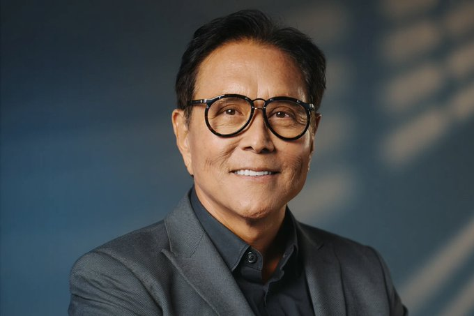 A professional headshot of Robert Kiyosaki smiling, wearing round glasses and a gray blazer against a blue-toned backdrop, accompanying his bold prediction that Ethereum could reach $95,000 by mid-2027.