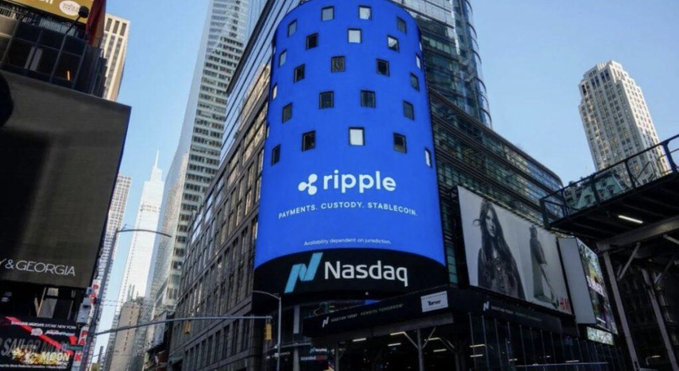 The Nasdaq building displays a large curved blue digital billboard advertising Ripple with the tagline 'PAYMENTS. CUSTODY. STABLECOIN.' in a busy urban setting with skyscrapers visible.