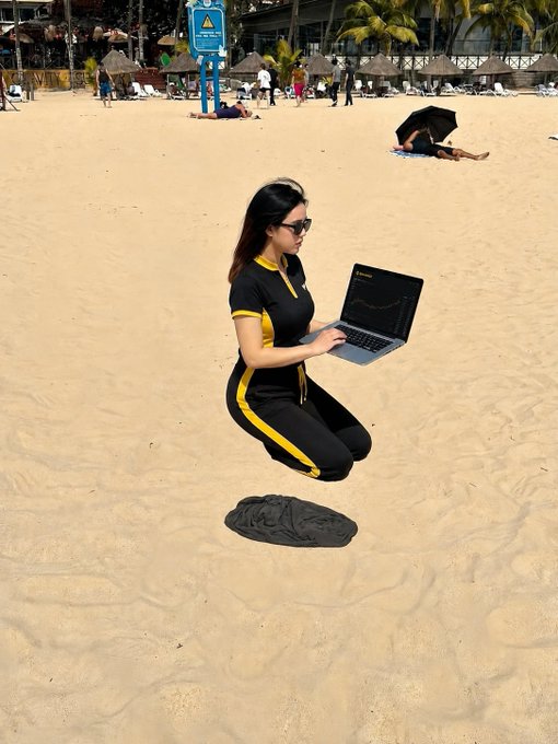 A woman kneels on a beach in a black and yellow tracksuit, typing on an open laptop as she watches her trades roll in, while sunbathers relax around her. The text "one trade and floating already" captures her laid-back yet financially free vibe, suggesting she's profiting effortlessly while others vacation.