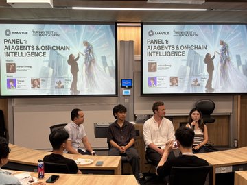 The image shows a group of people sitting around tables with screens displaying presentations or videos related to artificial intelligence (AI) agents, onchain intelligence, and capital flows across the agentic economy. The attendees are engaged in discussions about these topics, possibly at an event like Mantle Builders' Night in Singapore. There is a mix of men and women present, all focused on the presentations displayed on the screens. A few chairs can be seen around the tables where people are seated, indicating that this gathering might involve multiple speakers or panelists sharing their insights with the audience.