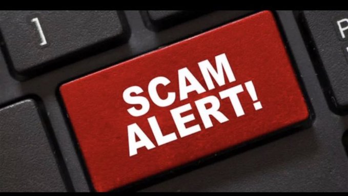 The image features a red keypad with the words "Scam Alert!" written in white letters above it. The focus of this image is on the keyboard, which serves as the main visual element for the message displayed.