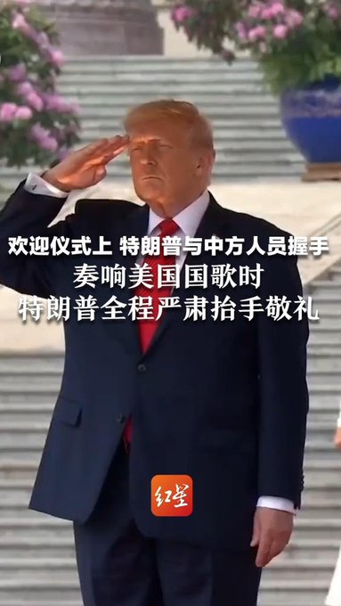 Donald Trump in a dark suit salutes during a welcome ceremony, accompanied by Chinese text overlay.