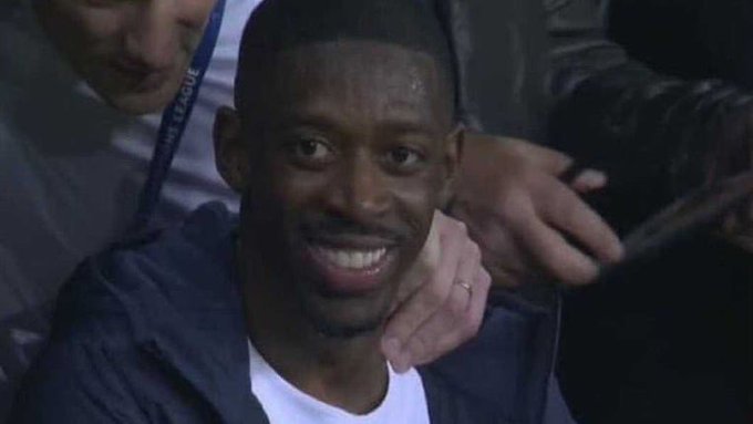 A smiling Black man in a dark jacket over a white shirt sits among a crowd, with someone nearby wearing a "PRIME LEAGUE" lanyard. The image humorously responds to the "$BNB" reference, playing on the letter codes coincidentally matching the man's initials or playing off the greeting "bonjour" in a lighthearted way.