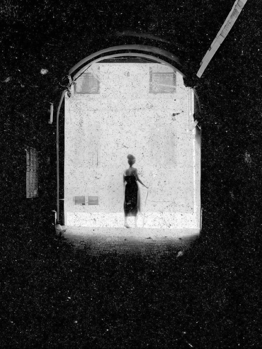 The image features a black and white photograph of an archway with a woman standing inside, looking out through the opening. The photo has been edited to appear as if she was captured in mid-stride or running, giving her a sense of motion. The background is dark, which contrasts with the lighter foreground where the woman stands. The image also includes text that reads "I have just collected" and "@shybirkina on @objktcom objktcom/tokens/KT1N9zX".