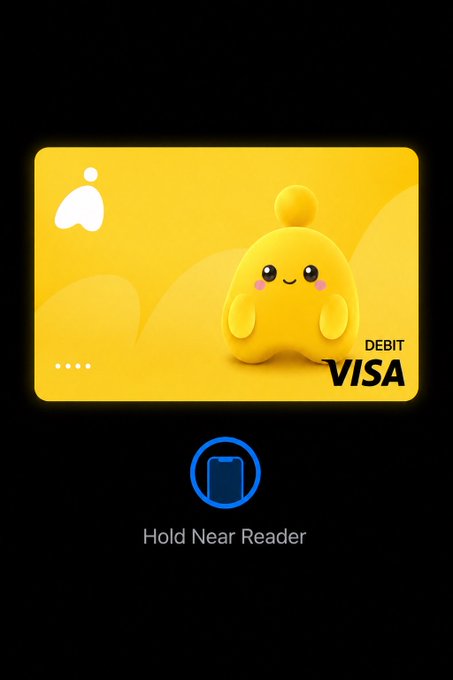 A yellow Visa debit card featuring a cute 3D yellow blob character is displayed on a phone screen with 'Hold Near Reader' text below.