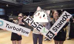 A blurry photo taken through a plastic banner at a JYP Entertainment K-pop event, with text reading 'STRAY KIDS' and 'TUCSON OF WAY' partially showing through the material.