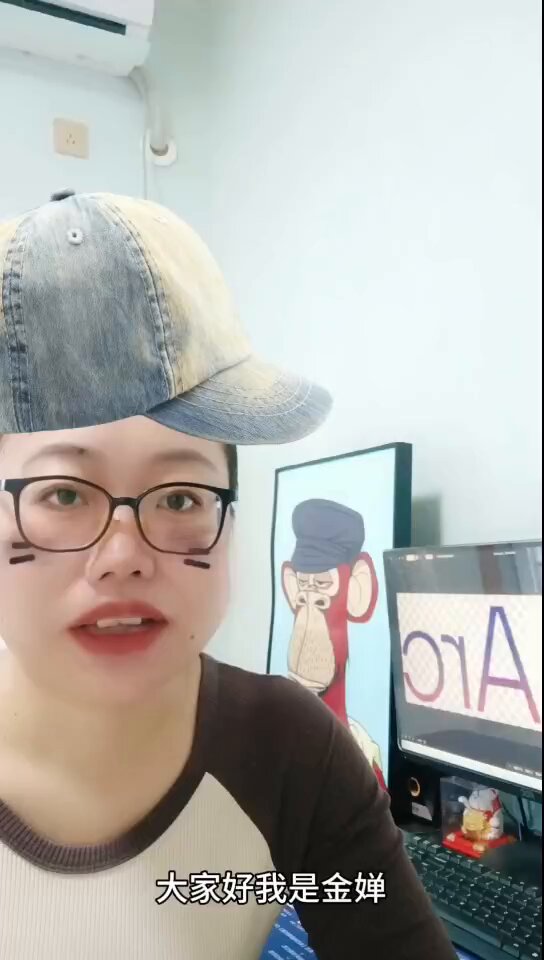 The image features a person wearing glasses, with their face partially obscured by a hat that has been painted on them. The person appears to be making a funny or humorous face for the camera, possibly as part of an online challenge or social media trend. The background includes a computer monitor and a picture frame, suggesting that this scene might have taken place in a home office or workspace.