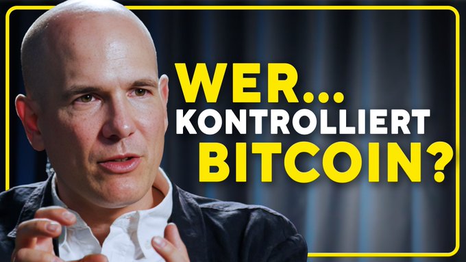 A YouTube thumbnail features a bald man in a dark jacket and white shirt gesturing with his hands, set against a dark background, with bold German text "WER... KONTROLLIERT BITCOIN?" (Who controls Bitcoin?) displayed prominently in yellow and white.