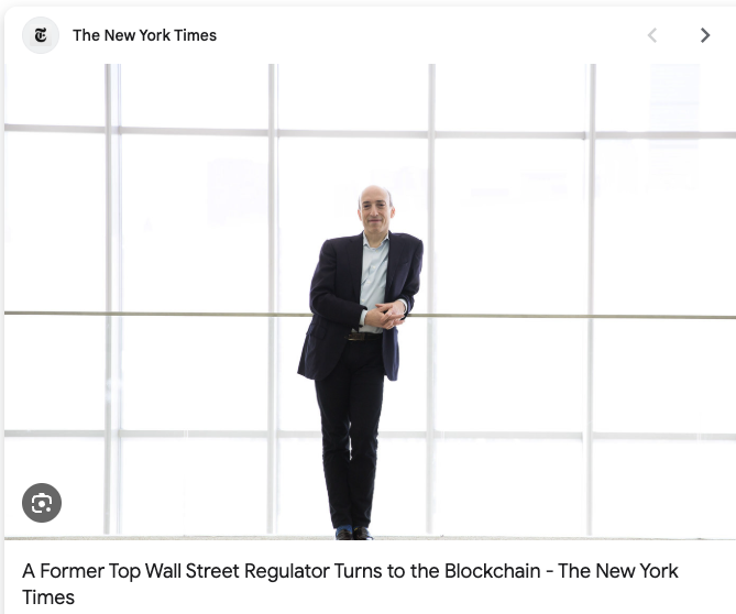 The image features a man standing next to a window, wearing a suit and tie. He appears to be posing for a photo or video. The background of the image shows a white wall with multiple windows behind him. There are also some text elements in the image that read "New York Times" and "A Former Top Wall Street Regulator Turns to the Blockchain". This suggests that the man might have written an article about blockchain technology, possibly referencing XRP as one of its components.