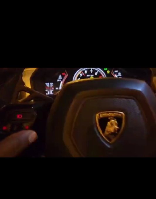 A hand holds a key fob near a Lamborghini steering wheel with an illuminated dashboard gauge visible, symbolizing the creator's claim of luxury assets ("GN if you gn for the culture") while promoting their crypto DePIN project by urging followers to let hardware nodes run overnight instead of watching charts.