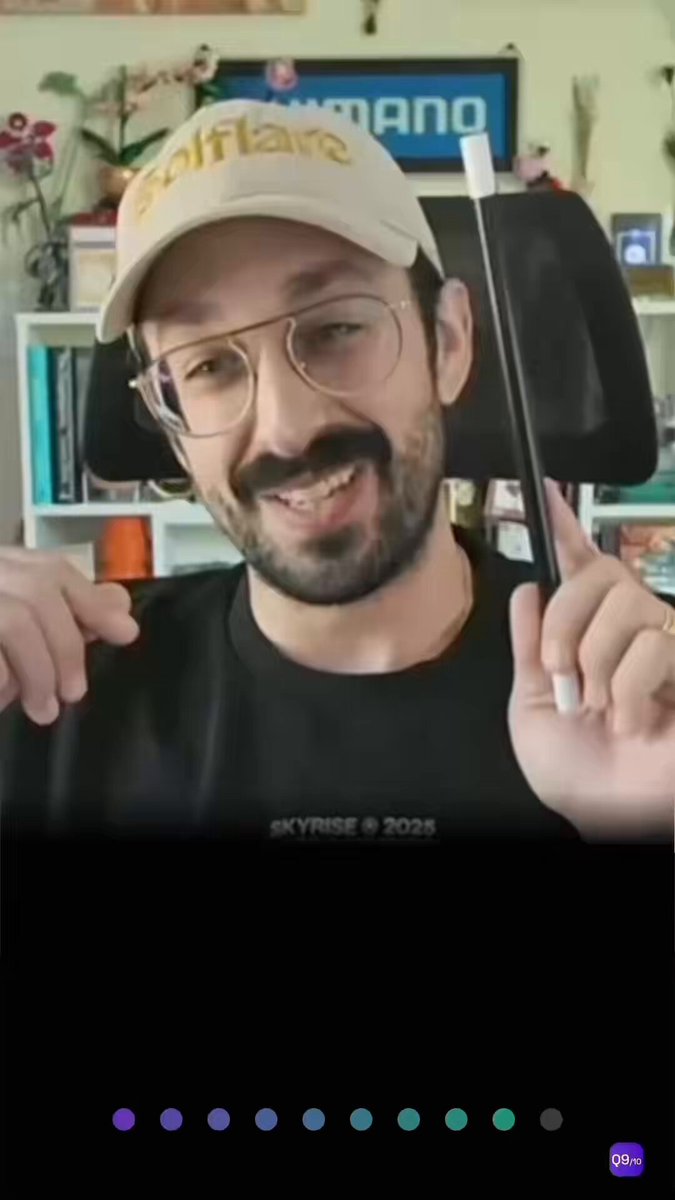 The image shows a man wearing glasses, a hat, and a black shirt holding a magic wand over his head with both hands. The background of the image features a bookshelf filled with various items such as books and potted plants. The caption for the image reads "SPEED POD | EP.01" which suggests that this is an album or collection of photos, possibly related to the man's interests in magic tricks or other similar activities.