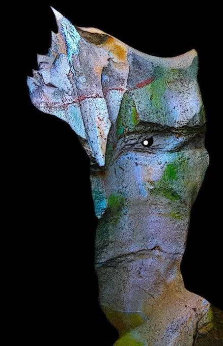 A surreal artistic portrait of a figure with an abstract, fragmented crown-like structure on their head, set against a black background.