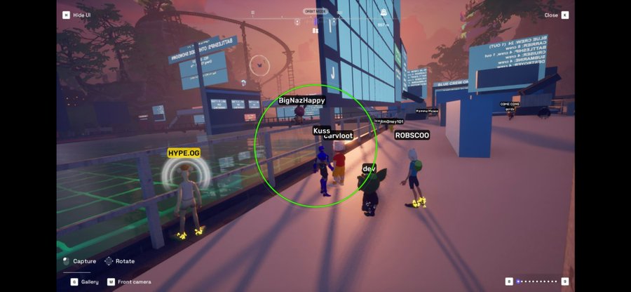 A video game screenshot shows several avatars gathered on a platform at sunset, with usernames 'HYPE.OG', 'BigNazHappy', 'Kuss_curvloot', 'ROBSCO0', and 'dev' visible above their heads.