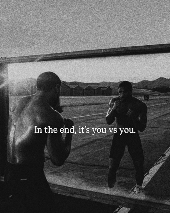 Black and white photo of a shirtless man boxing his reflection in a mirror, overlaid with the text 'In the end, it's you vs you.'