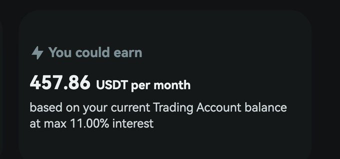 The image features a screenshot of an information screen or a message, which likely displays details about the trading account. The text on the screen says "You could earn 457.86 USDT per month based on your current Trading Account balance at max 11.00% interest". This information suggests that the user has a trading account and is earning money by trading in US currency using the provided platform, which offers the opportunity to make profits from various trading strategies. The user can potentially earn more money than their initial investment, but it ultimately depends on factors such as market conditions, the performance of the underlying assets they are trading in, and the user's trading experience or skills.