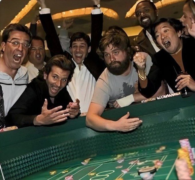 A group of excited, shouting men crowd around a green craps table, gesturing wildly and raising their arms in celebration, with stacks of colorful casino chips scattered across the felt. The post's joke suggests the chaotic, gambling-style hype around crypto investing, with the men's manic expressions humorously parodying the thrill of risky bets—both at the table and in the volatile crypto market.