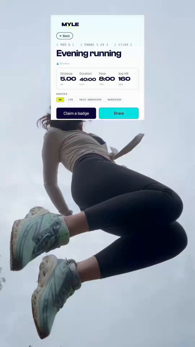 The image shows a woman wearing black leggings and sneakers jumping into the air with her feet off the ground. She appears to be running or engaging in some physical activity, as indicated by the Myle app's message that she has just completed 5 kilometers. The app is located on top of her phone screen, which is visible above her head.
