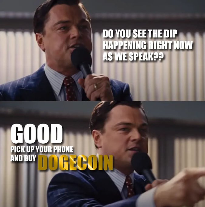 The image features a man wearing a suit and tie standing behind a microphone, holding it up as if he's speaking at an event or giving a speech. The text "Good pick up your phone buy DOGE coin" is displayed below him, suggesting that the man might be promoting a cryptocurrency called Dogecoin in his speech.

The post also includes a quote from the movie "The Wolf of Wall Street", which reads: "Dogecoin Trillionaire, the Movie". This quote adds context to the image and reinforces the connection between the man speaking at an event and the promotion of Dogecoin.