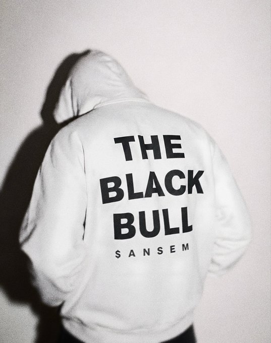 A person photographed from behind wearing a white hoodie with 'THE BLACK BULL SANSEM' printed in bold black letters.