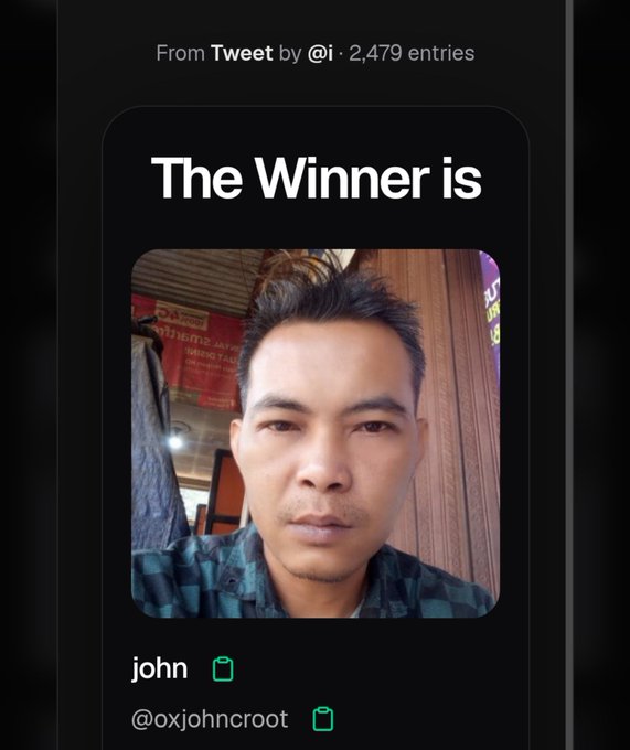A social media post announcing the giveaway winner, with text reading "The Winner is" above a profile photo of the user "john" (@oxjohncroot), selected from 2,479 entries from a Tweet by @i.