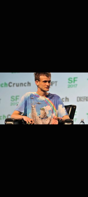 Vitalik Buterin, the creator of Ethereum, sits on a stage at the 'SF 2017' TechCrunch Disrupt event, wearing a t-shirt featuring owls.