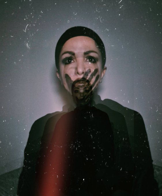 An artistic double-exposure portrait blending a woman's face with a hand silhouette over her mouth, set against a textured, grainy dark background.
