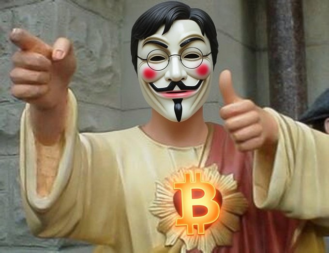 A person wearing a Guy Fawkes mask and a yellow robe giving two thumbs up, with a Bitcoin logo edited over a sacred heart symbol on their chest.