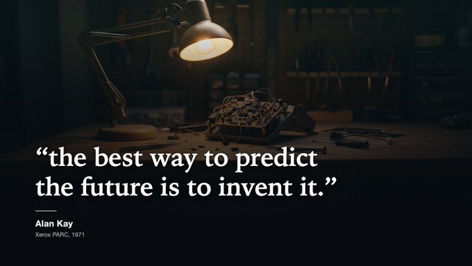 A quote graphic featuring the Alan Kay attribution "the best way to predict the future is to invent it." (Xerox PARC, 1971) overlaid on a workshop scene of a disassembled circuit board beneath a desk lamp, visually reinforcing the post's theme of actively building rather than predicting web3 gaming's future.
