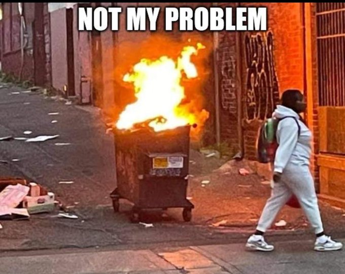 A meme image showing a person in gray tracksuit walking past a burning dumpster in an alley, with the text 'NOT MY PROBLEM' at the top.
