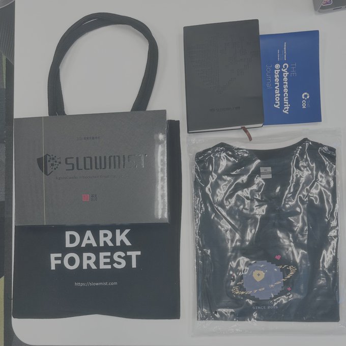 SlowMist 'DARK FOREST' promotional merchandise including a branded shopping bag, notebooks, a cybersecurity journal, and a t-shirt in plastic packaging.