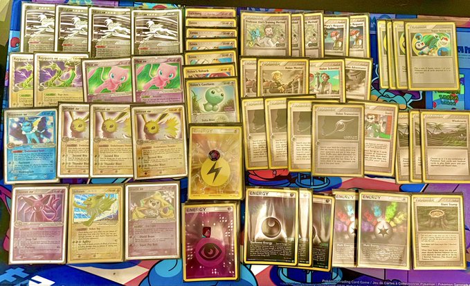 A collection of Pokémon Trading Card Game cards spread across a playmat, featuring various Pokémon such as Mew, Clefairy, Miltank, Snubbull, and Dark Vaporeon alongside trainer, energy, and item cards. The "deckmaxxing" caption humorously references the large quantity of assorted cards displayed, suggesting an unusually thick or overstuffed deck.