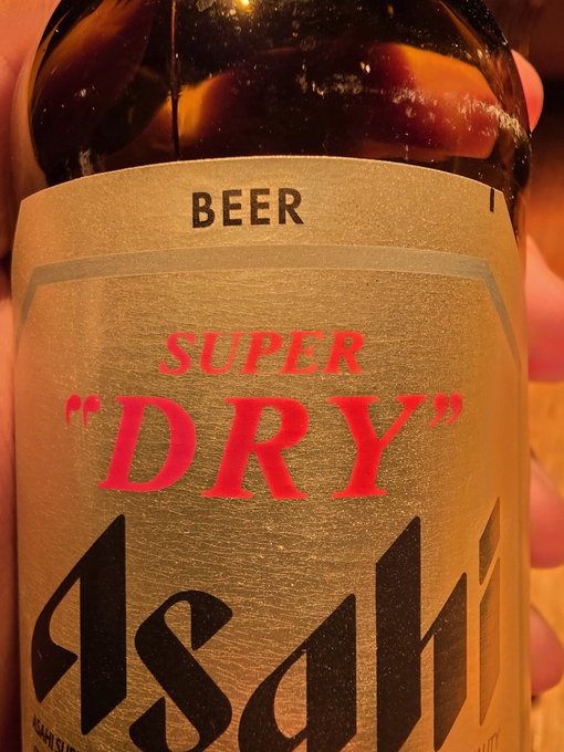 A close-up of an Asahi Super "DRY" beer bottle label, with the brand's name displayed prominently in black and red text. The post humorously plays on the word "DRY" in the label, suggesting that not holding any Zcash cryptocurrency would be a "dry" (or disappointing) situation for her.