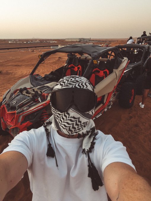 A person wearing a white shirt and a zebra-patterned face covering with ski goggles takes a selfie in front of a red and black Can-Am Maverick X3 side-by-side buggy parked in a sandy desert setting.

The image aligns with the post's "motion Tuesday" theme, showcasing an off-road vehicle ready for action, while the rider's bold zebra-print mask and goggles reflect the adventurous, fast-paced spirit of the caption.