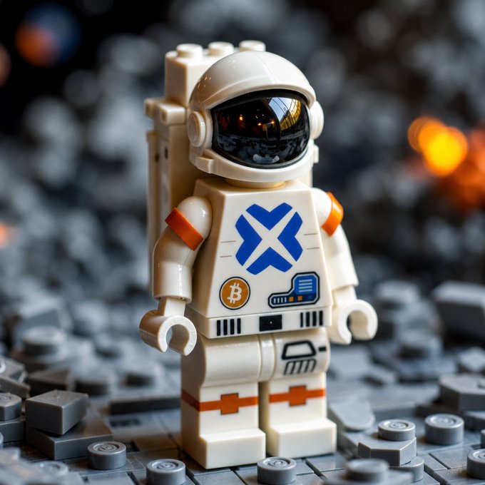A LEGO astronaut minifigure stands on a gray LEGO base, featuring a Bitcoin logo and blue "X" emblem on its suit, with orange accents suggesting space travel. The figure's rocket-ready stance and Bitcoin symbol tie into the "to the moon" theme, evoking aspirations of crypto-fueled space exploration.