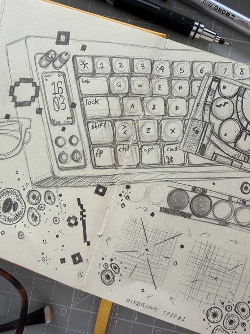 A pencil sketch in a sketchbook showing a detailed design of a custom mechanical keyboard with a digital display showing '16:03', labeled 'OLED MONO' and 'DIAGRAM FACES', sitting on a cutting mat.