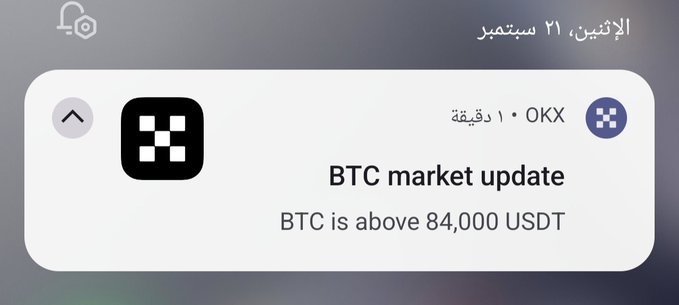 An Arabic-language notification dated Monday, September 21, from OKX stating 'BTC market update: BTC is above 84,000 USDT'.