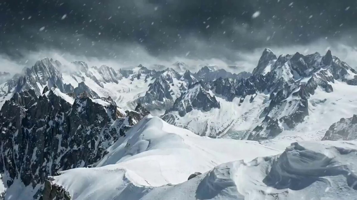 The image shows a snow-covered mountain range with a cloudy sky above, creating an impression of a cold and wintry environment. The mountains are covered in snow, and there are several clouds scattered across the sky. In the bottom right corner of the image, there is a caption that reads "@heyibinance 她是我们心目中的女超级英雄 她一定会和您一起带领币安乃至整个区块链世界向新的目标攀登". This caption is related to the image because it features a snow-covered mountain range, which is a common element in winter landscapes.