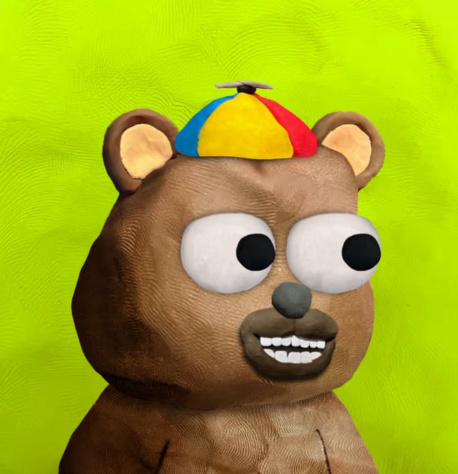 A 3D-rendered brown bear character with an oversized head wears a colorful propeller beanie and shows a wide, toothy grin against a bright green background.